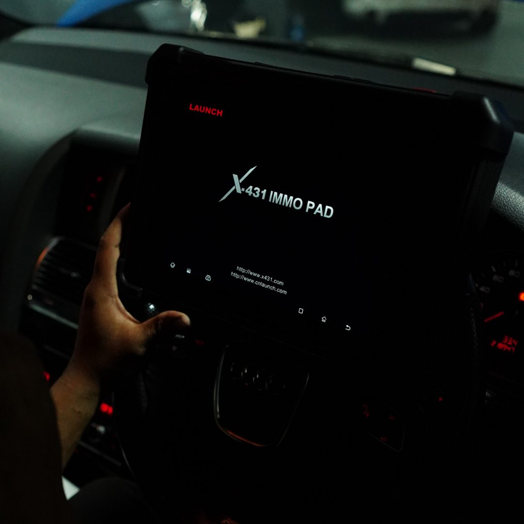 Technician using a diagnostic scanner inside a customer's car